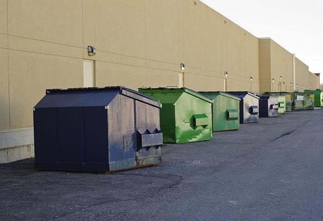 a waste management truck unloading into a construction dumpster in Paducah KY